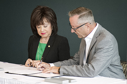 OPCMIA General President Daniel Stepano (right) signs a contract to host his organization's Instructor Training Program on the WCC campus as WCC President Dr. Rose B. Bellanca looks on.