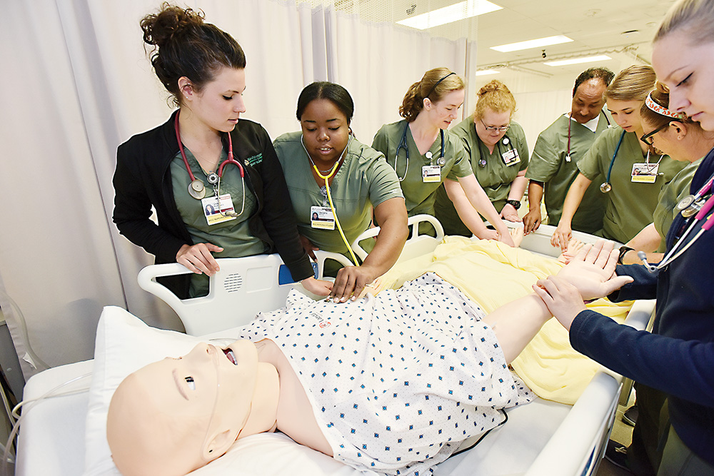 Students from a Nursing Concepts I class at Washtenaw Community College are introduced to some capabilities of the college’s new patient simulator. | Photo by Lon Horwedel