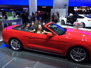 WCC students enjoy a stationary ride in a Ruby Red 2016 Ford Mustang GT convertible at the 2016 North American International Auto Show. Photo by Susan Ferraro. 