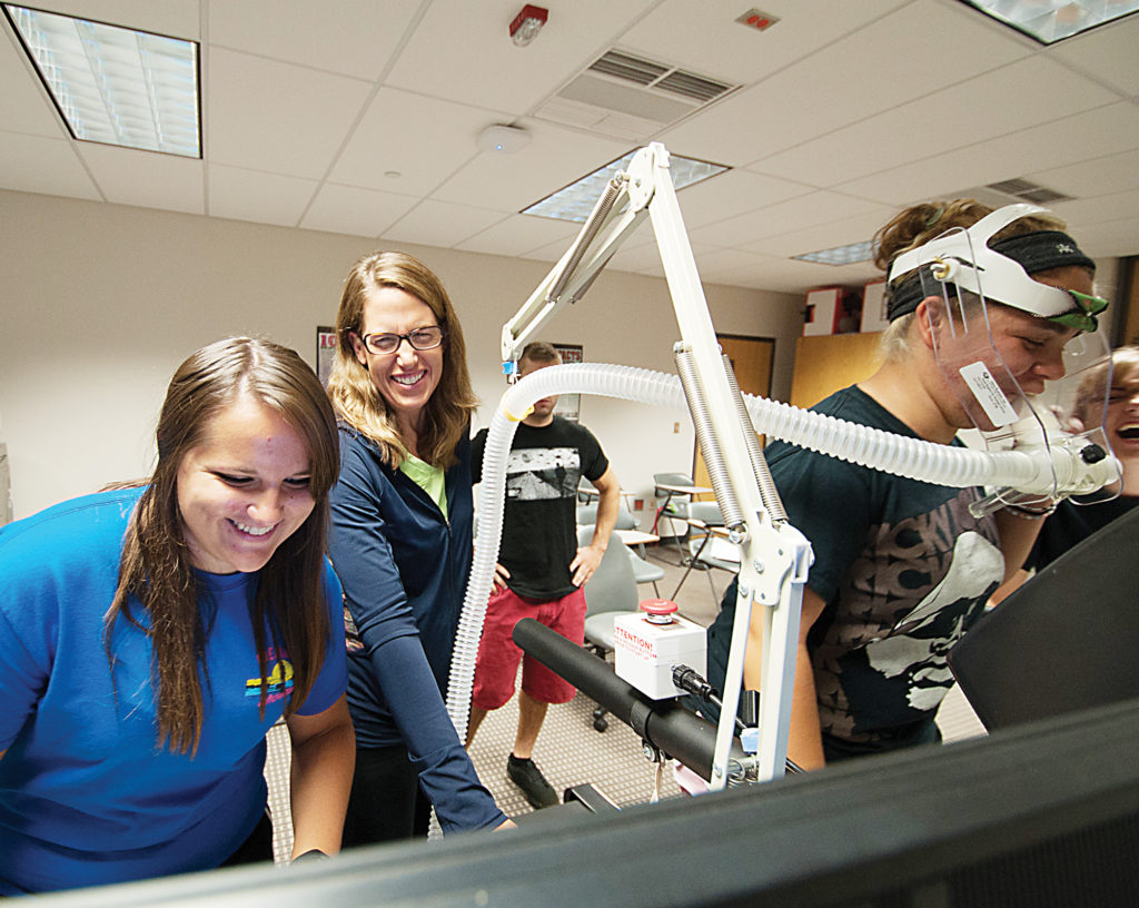 WCC faculty member Ann Brennan (center) monitors a student measuring oxygen volume of another student. The VO2 Max test is considered the gold standard for assessing overall fitness. (Photo by Jessica Bibbee)