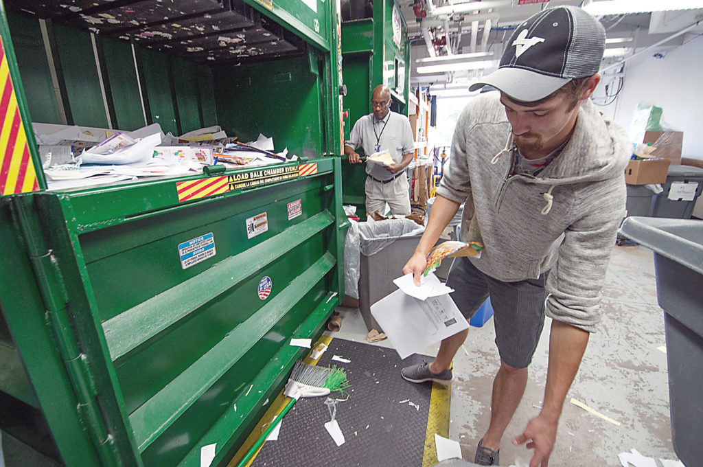 Student Joe Chapman (right) and Barry Wilkins, WCC manager of recycling operations, sort through paper and plastic at the college’s Recycling Center. (Photo by Jessica Bibbee)